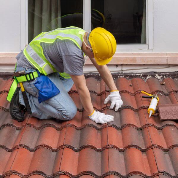 Roofer from Roofing Guys Central Coast replaces damaged tiles during a full residential tile roof replacement. Roofer from Roofing Guys Central Coast replaces damaged tiles during a full residential tile roof replacement.