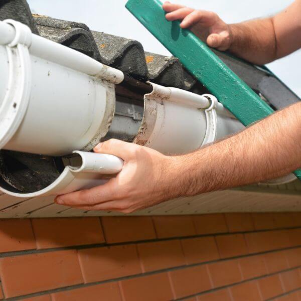 Roofing Guys Central Coast carrying out gutter repairs on a tiled roof. We fix cracked, leaking, and rusted gutters with professional replacements and maintenance services.
