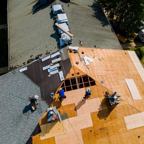 Roofing Guys Central Coast crew installing a new roof during a home renovation project, showing exposed timber sheeting and partial shingle coverage. Roofing Guys Central Coast inspector completing a roof damage assessment and report for a residential insurance claim on the Central Coast.