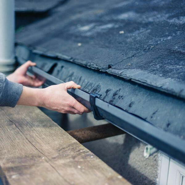 Roofing Guys Central Coast technician repairing a residential gutter to fix drainage issues and prevent water damage. Roofing Guys Central Coast technician repairing a residential gutter to fix drainage issues and prevent water damage.