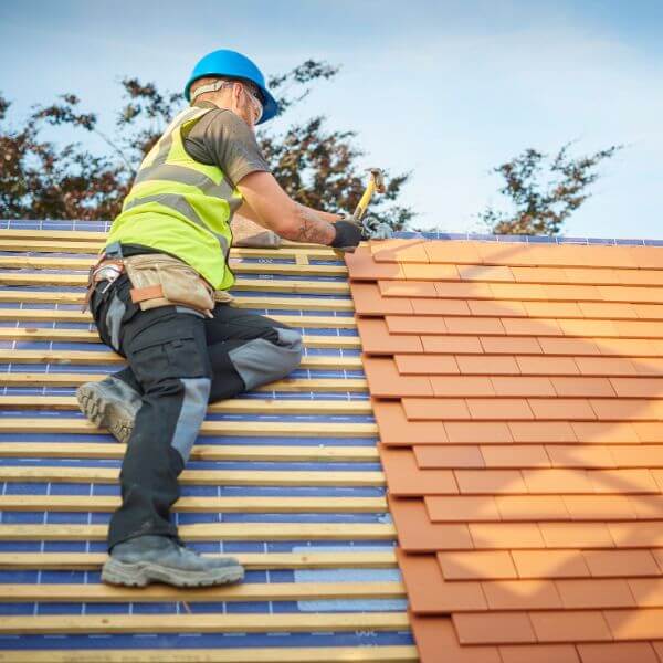 Roofing Guys Central Coast carrying out roofing services in Central Coast installing new terracotta tiles and ensuring a secure weatherproof finish.
